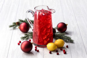 Pitcher of cranberry lemonade with Christmas ornaments
